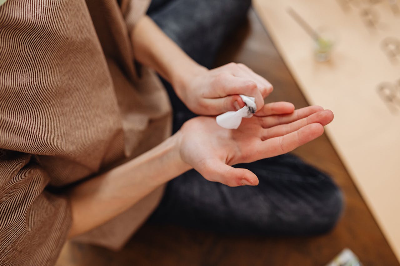 Close-up of persons hands holding crumpled white paper indoors, creating a thoughtful moment.