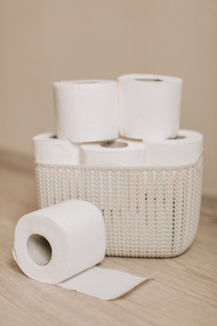 A cozy and organized display of toilet paper rolls neatly stacked in a woven basket.